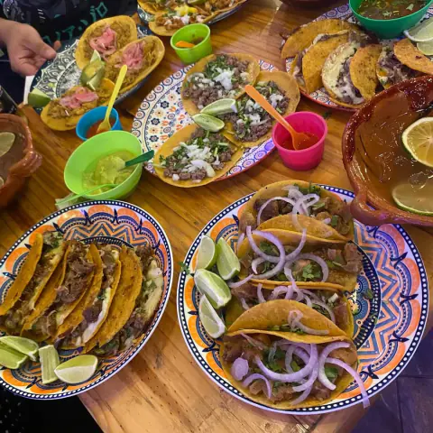 Mesa con varios platos de tacos y salsas