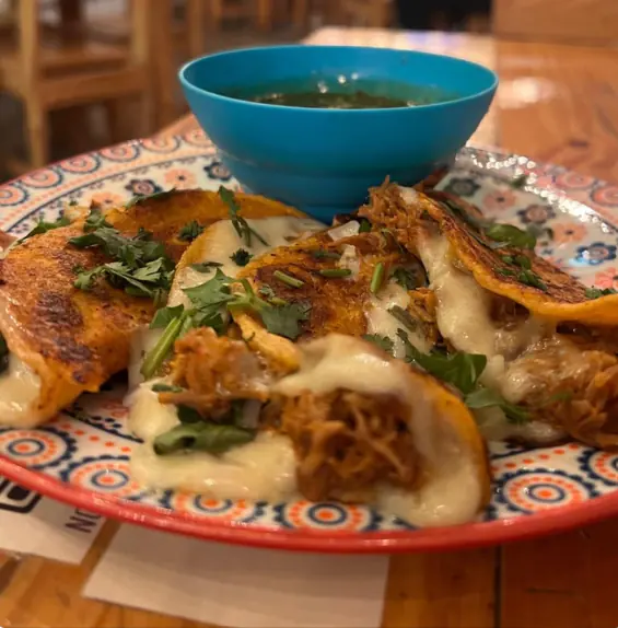 Quesabirrias doradas con queso derretido y su caldo
